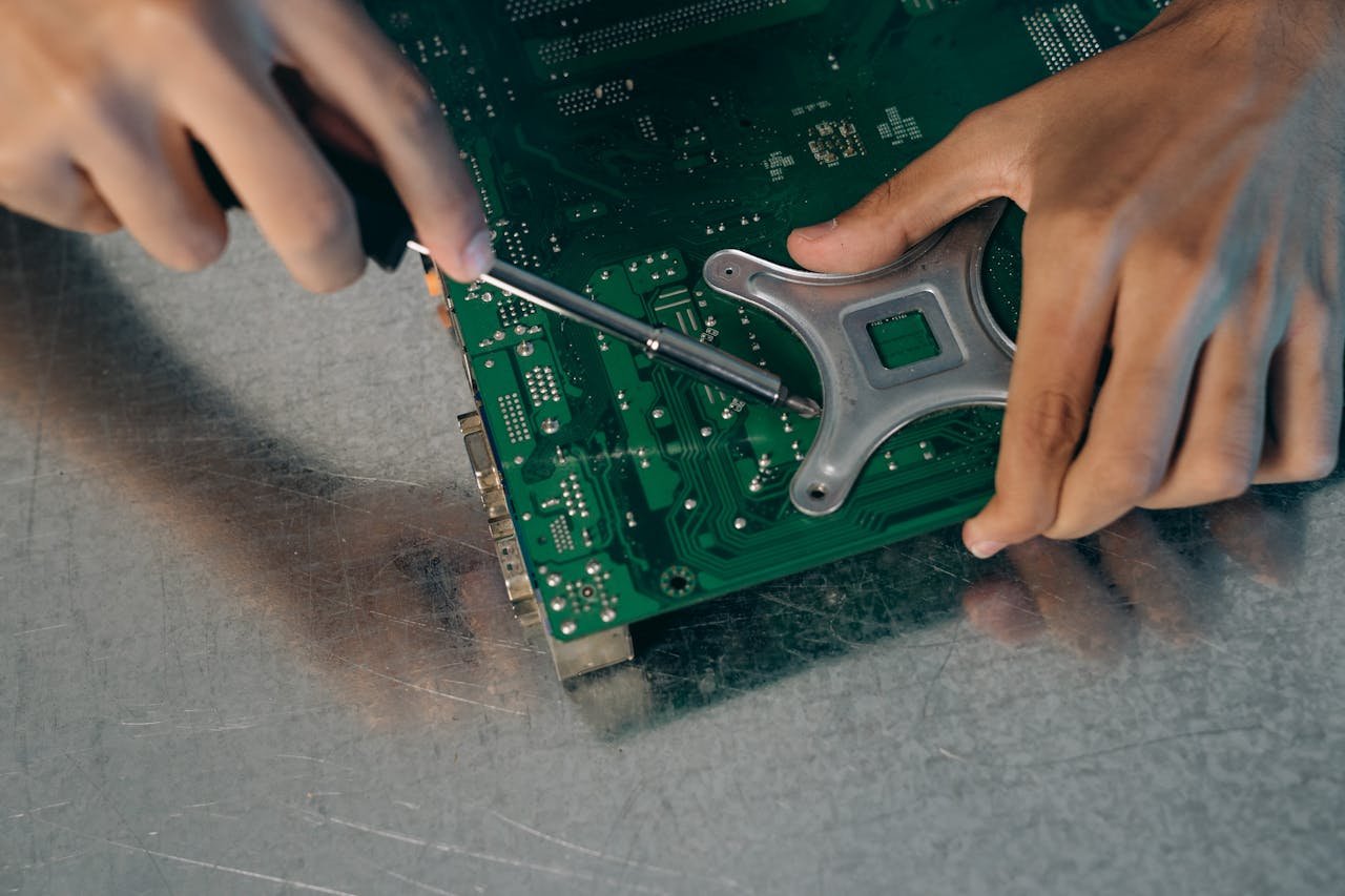 services-02 Detailed view of an engineer assembling a circuit board with a screwdriver.